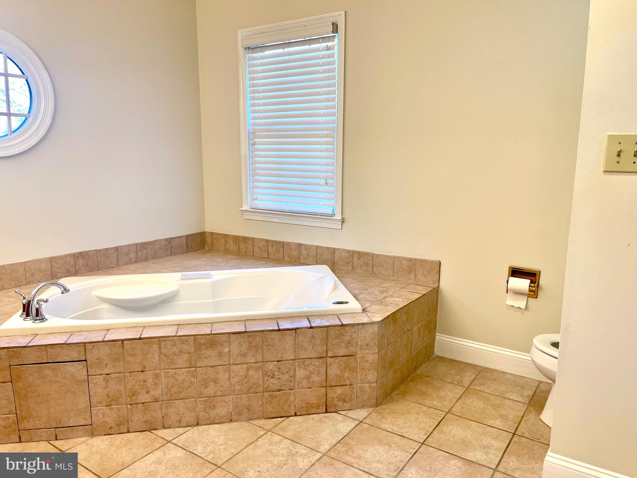 11803 Bishops Content Road Bowie, MD 20721 - Photo 32 of 54 a bathroom with a tub and a window