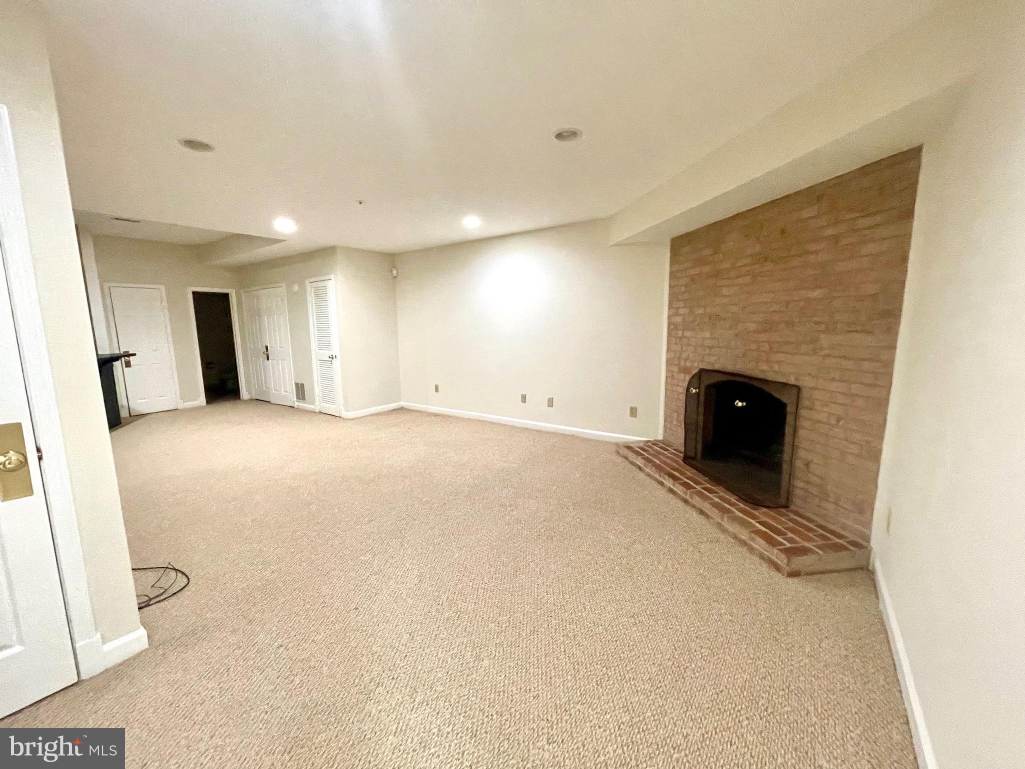 11803 Bishops Content Road Bowie, MD 20721 - Photo 45 of 54 Basement with fireplace and brick accent wall