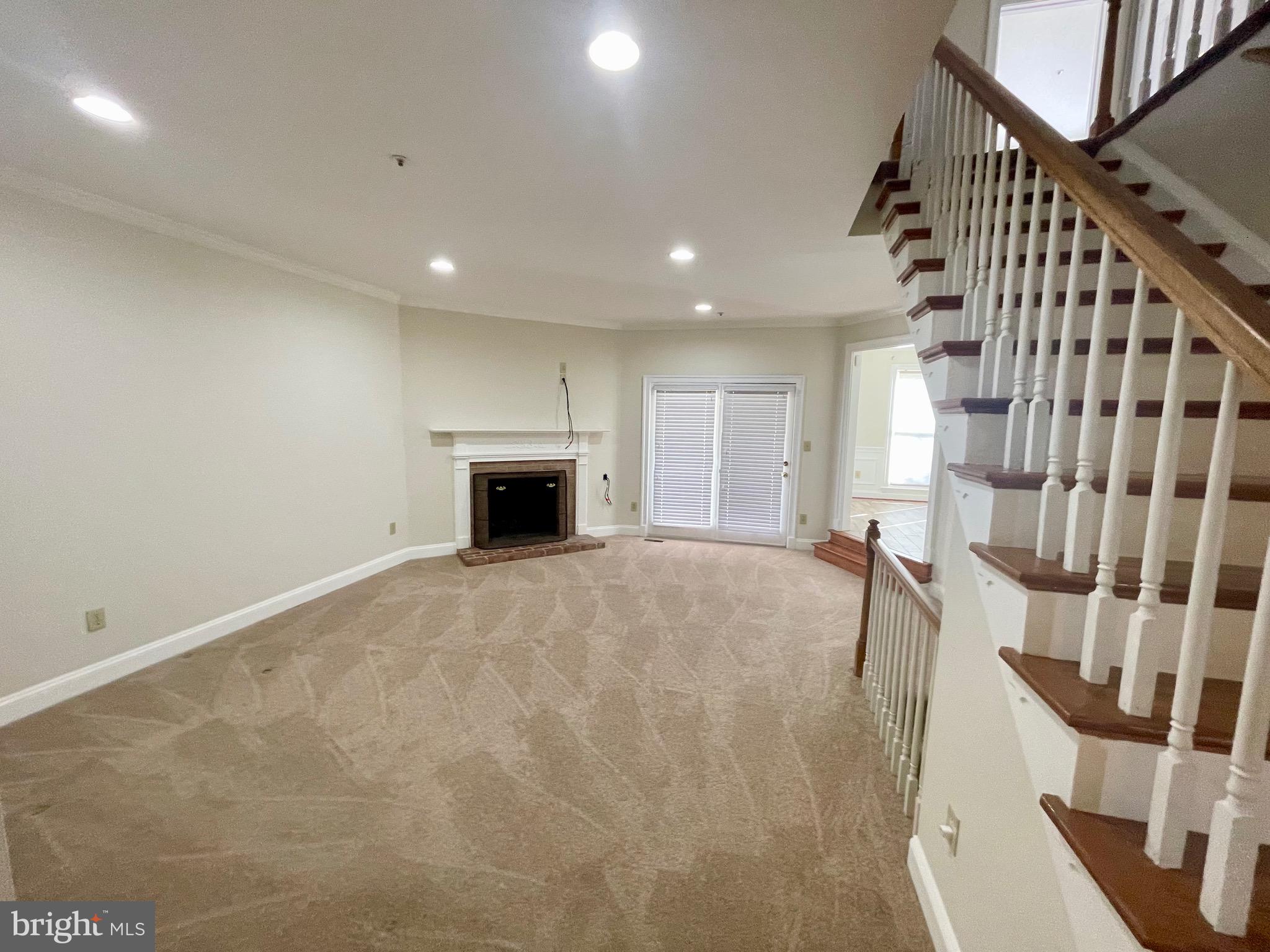 11803 Bishops Content Road Bowie, MD 20721 - Photo 5 of 54 a view of an empty room with wooden floor and a fireplace