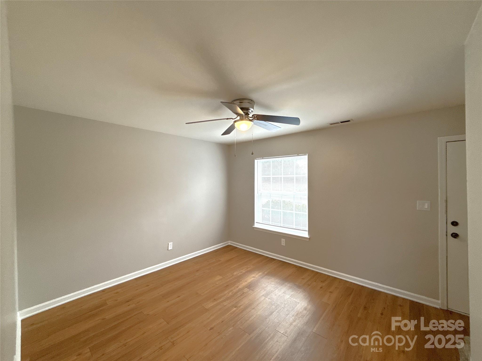 409 Hawley Avenue, Unit 7 Belmont, NC 28012 - Photo 2 of 12 an empty room with wooden floor fan and windows