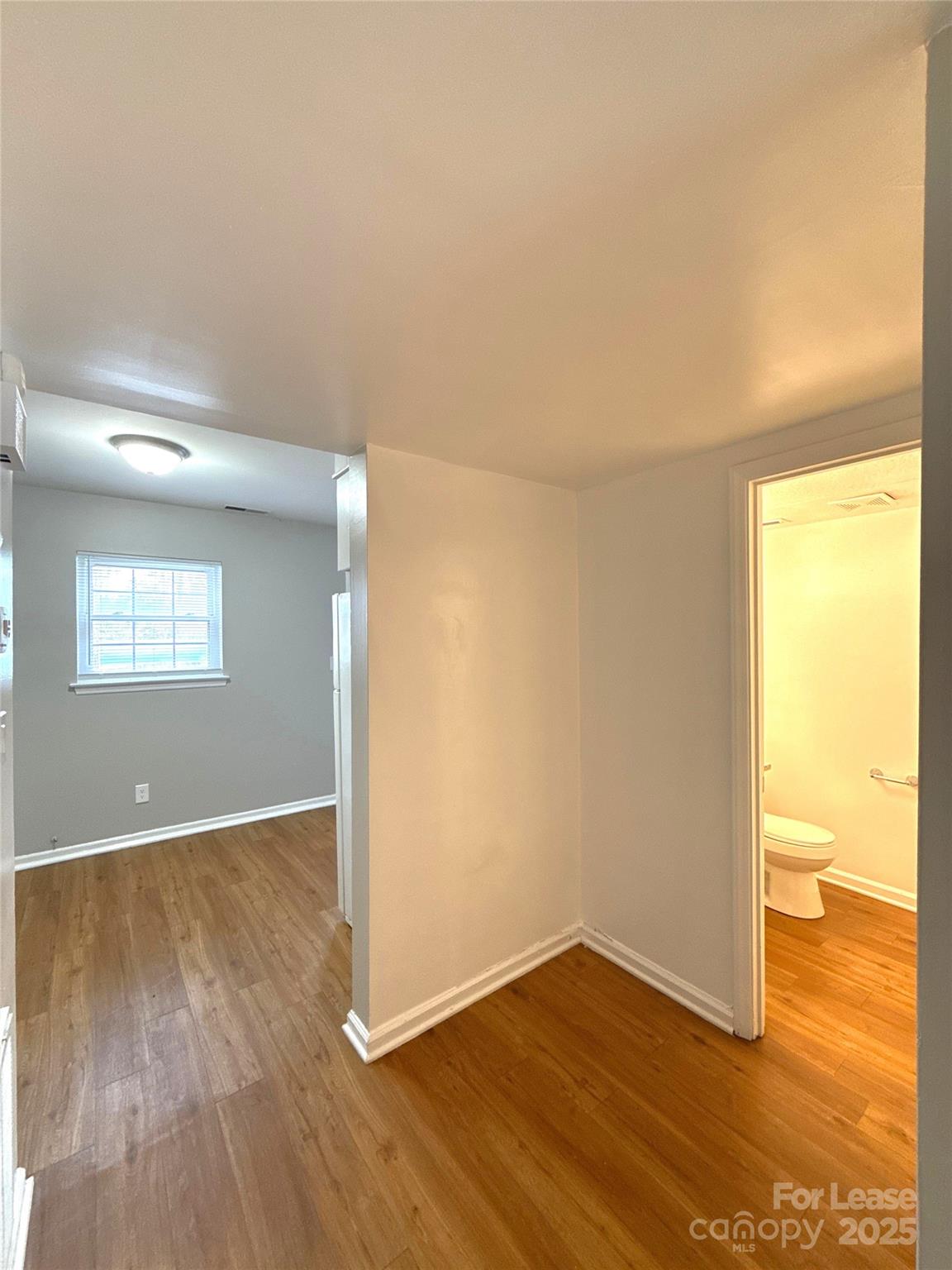 409 Hawley Avenue, Unit 7 Belmont, NC 28012 - Photo 4 of 12 an empty room with wooden floor and windows