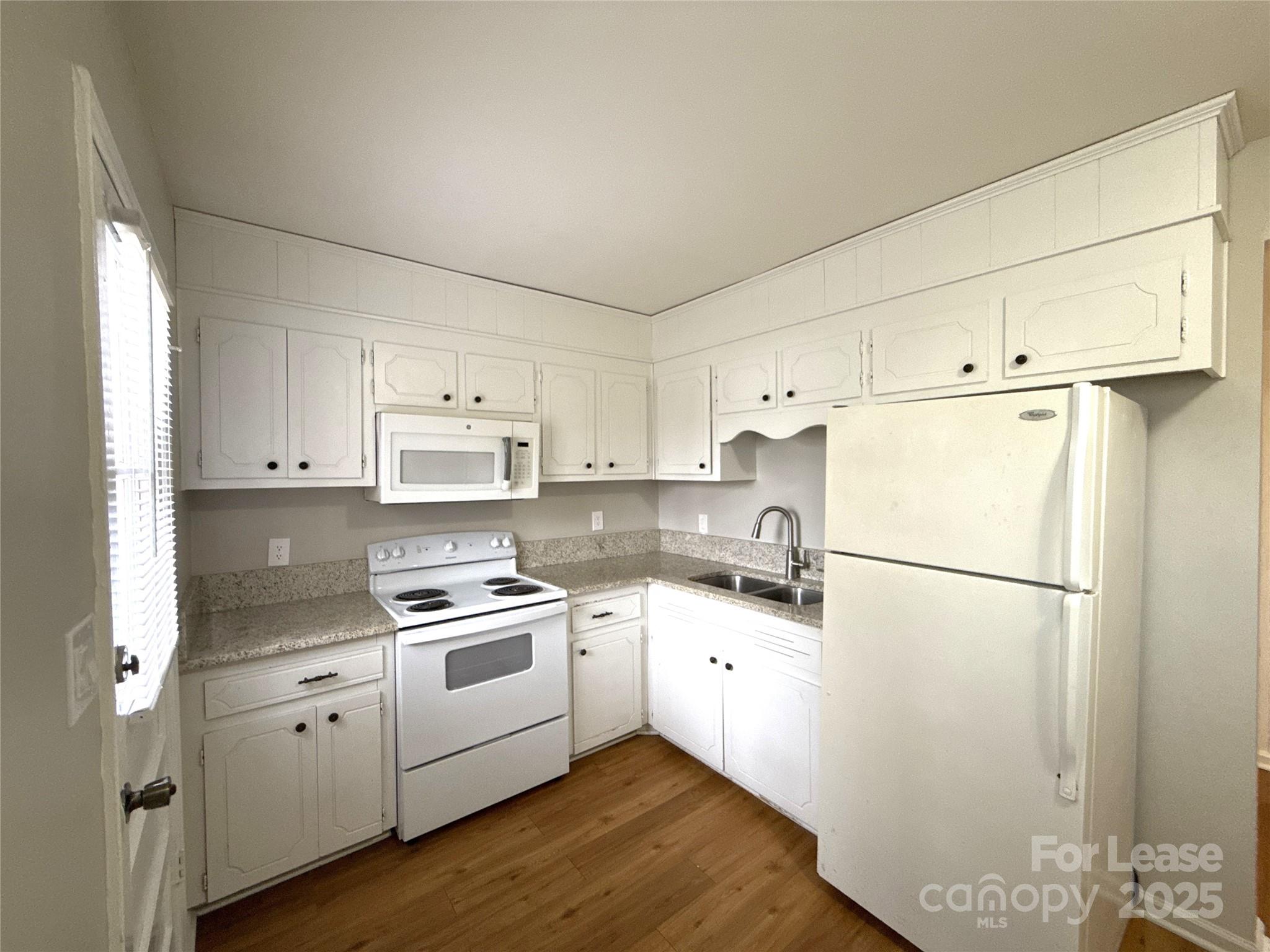 409 Hawley Avenue, Unit 7 Belmont, NC 28012 - Photo 6 of 12 a kitchen with white cabinets and white appliances