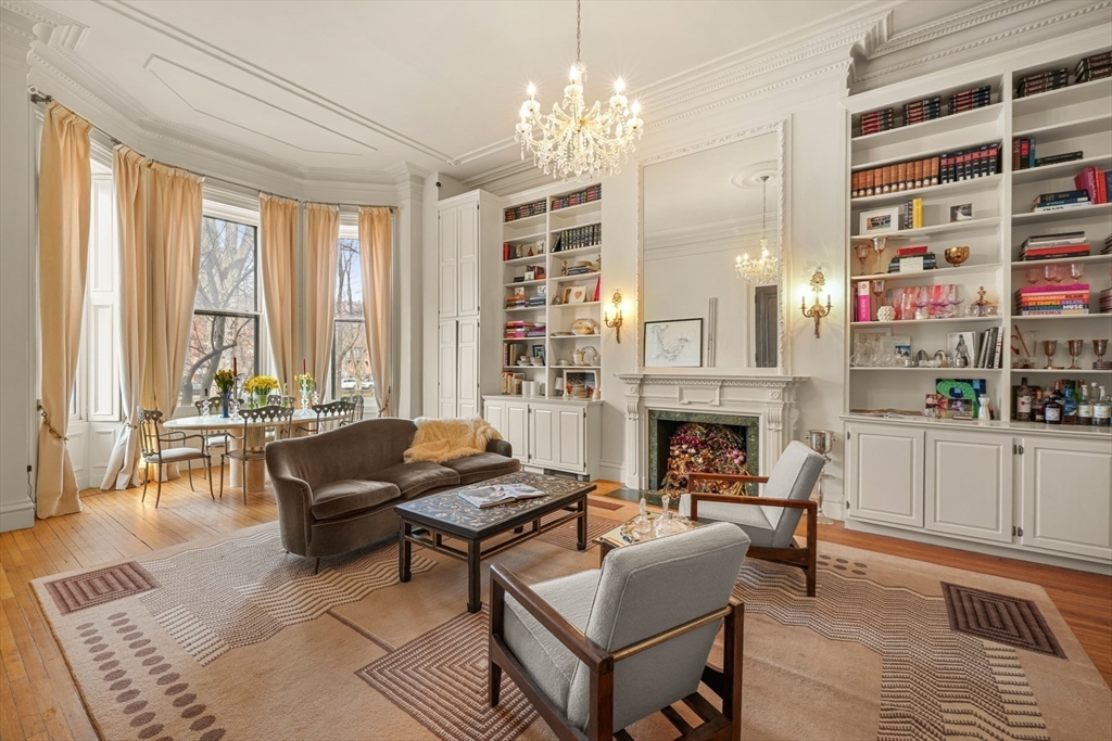 a living room with furniture a fireplace and large windows