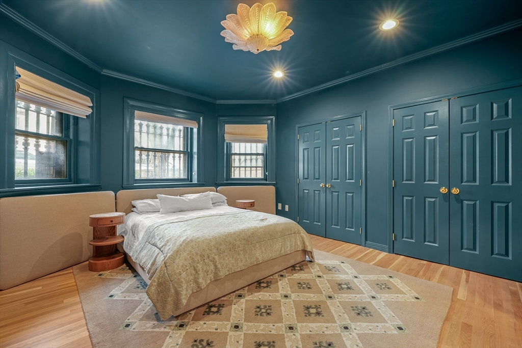 116 Commonwealth Avenue, Unit 1 Boston, MA 02116 - Photo 15 of 27 a bed sitting in a spacious bedroom next to a window and a chandelier