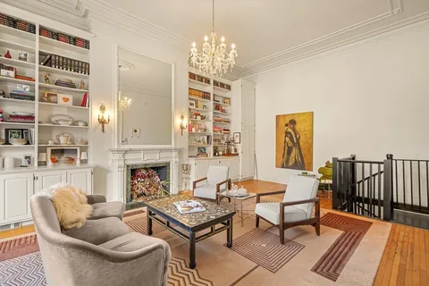 a living room with fireplace furniture and a chandelier