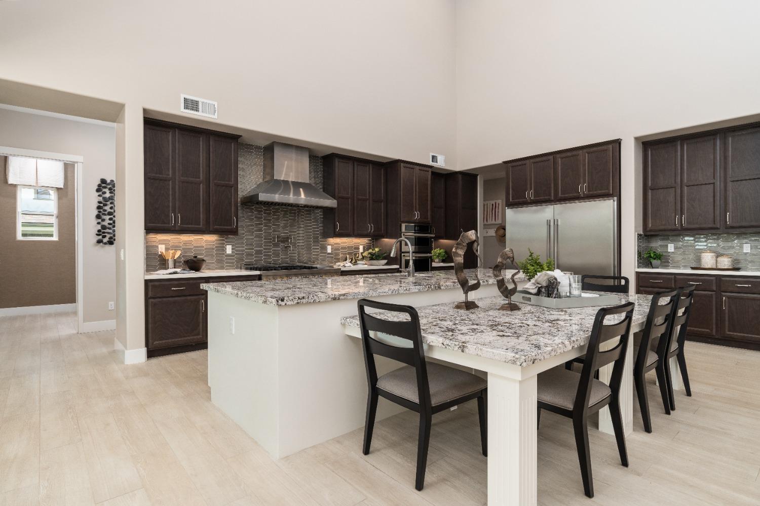 1764 Lester Avenue Clovis, CA 93619 - Photo 14 of 51 a kitchen with kitchen island granite countertop wooden cabinets a refrigerator a stove a microwave and island with wooden floor