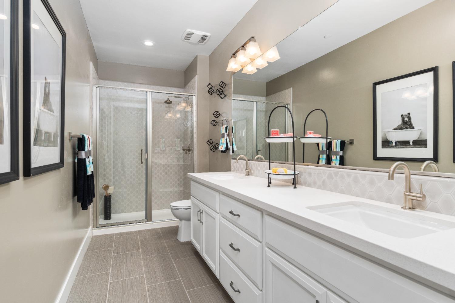 1764 Lester Avenue Clovis, CA 93619 - Photo 37 of 51 a spacious bathroom with a double vanity sink a toilet a mirror and shower