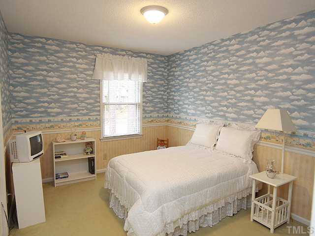 1509 Falls Church Road Raleigh, NC 27609 - Photo 13 of 18 a bedroom with a bed and a chair