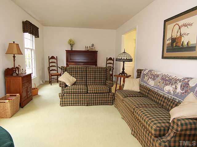 1509 Falls Church Road Raleigh, NC 27609 - Photo 3 of 18 a living room with furniture a flat screen tv and a refrigerator
