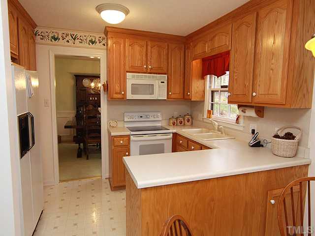 1509 Falls Church Road Raleigh, NC 27609 - Photo 5 of 18 a kitchen with a refrigerator a stove top oven a sink and dishwasher
