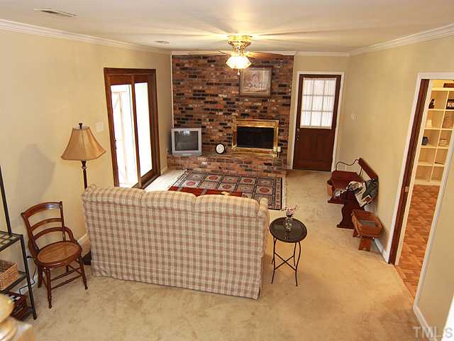 1509 Falls Church Road Raleigh, NC 27609 - Photo 8 of 18 a living room with furniture a chandelier and a flat screen tv