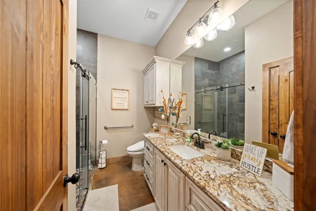 a bathroom with a granite countertop sink a mirror and a shower