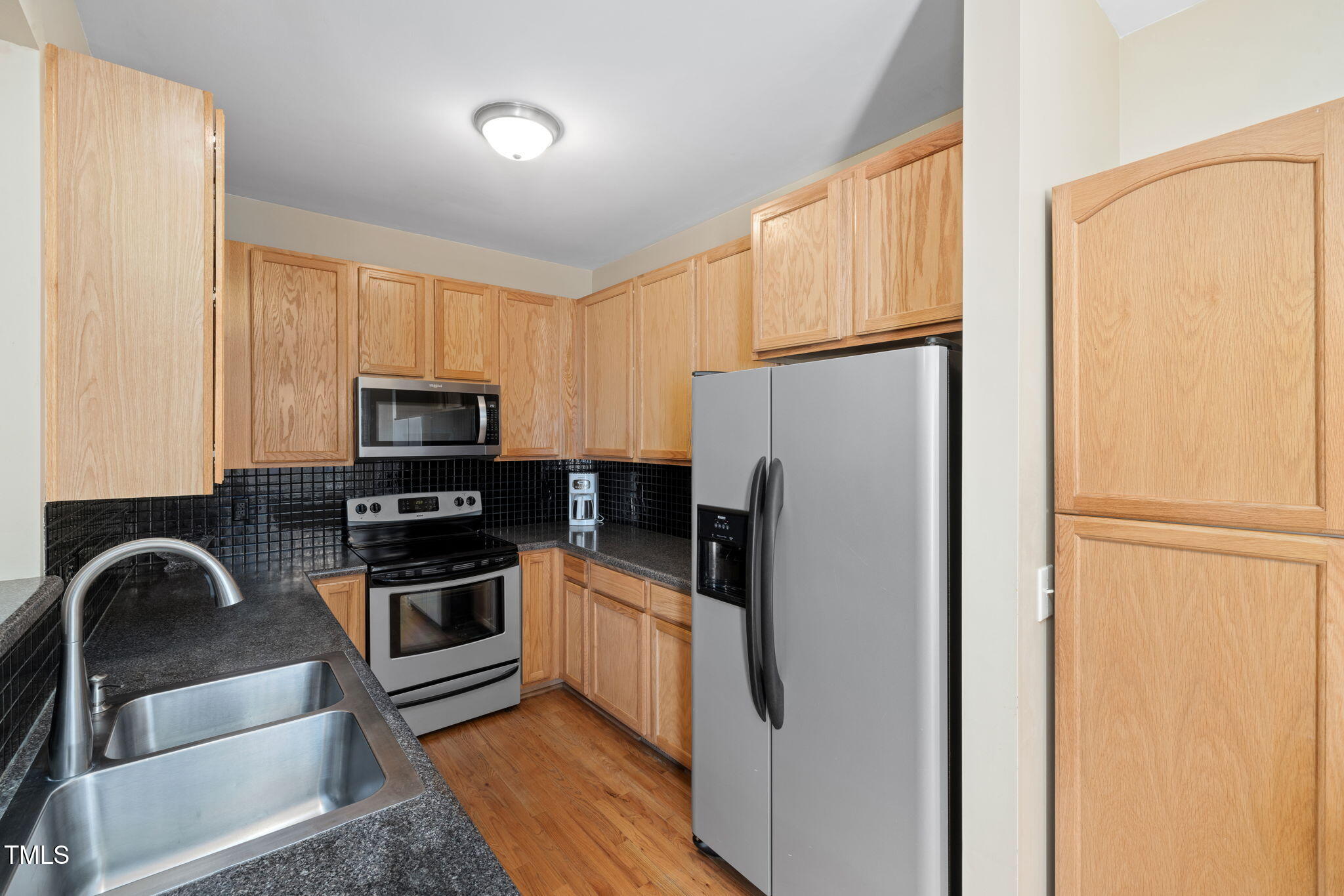 5569 Sea Daisy Drive Raleigh, NC 27606 - Photo 9 of 31 a kitchen with stainless steel appliances a refrigerator sink and white cabinets