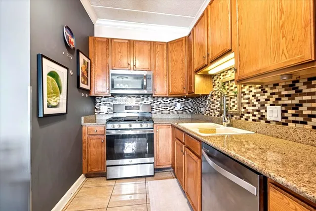 a kitchen with stainless steel appliances granite countertop a sink stove and cabinets