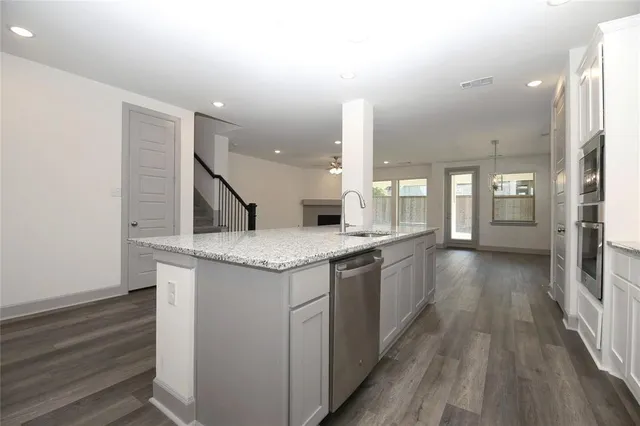an open kitchen with a sink and dish washer