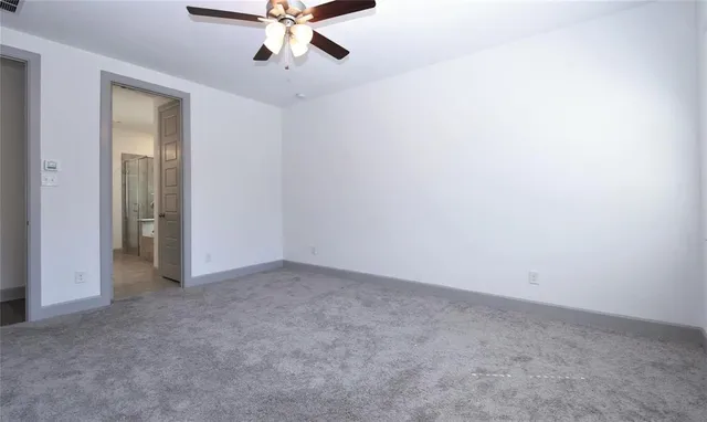 an empty room with a chandelier fan