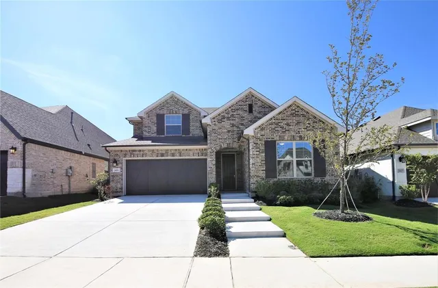 a front view of a house with a yard and a garage
