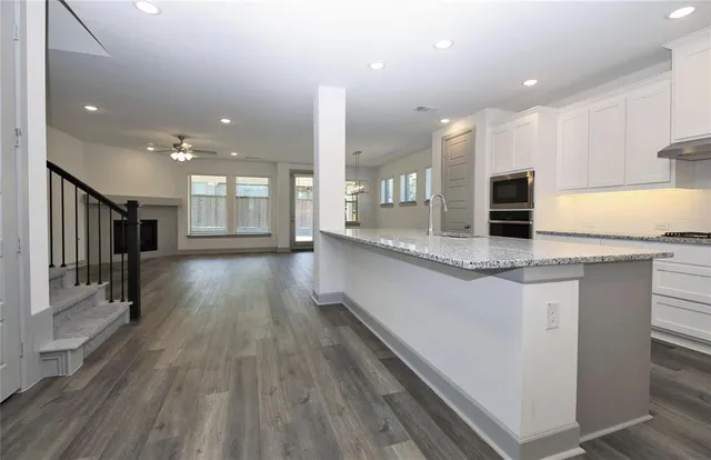a large kitchen with kitchen island a large counter space a sink appliances and cabinets