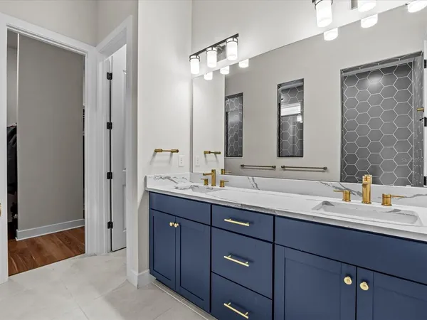 a bathroom with double vanity sinks and a mirror