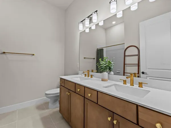 a bathroom with a sink a toilet and a mirror