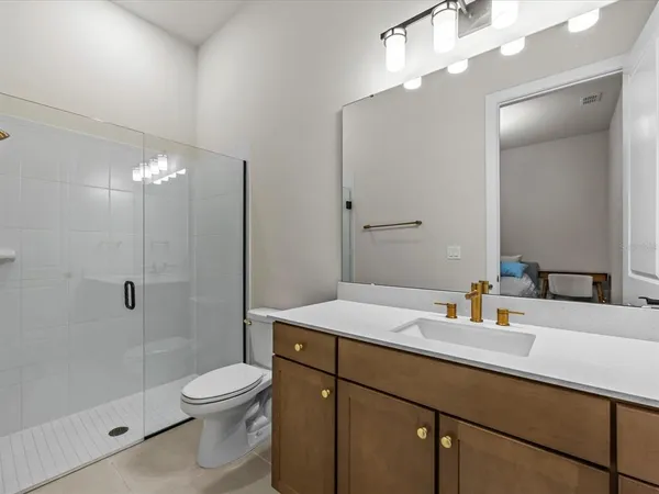 a bathroom with a sink a toilet and shower