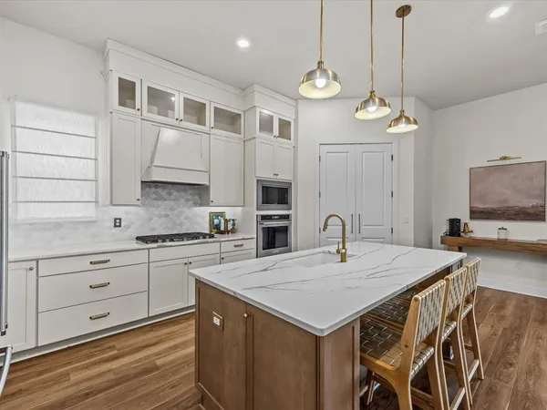 a kitchen with a stove a kitchen island a cabinets and wooden floor