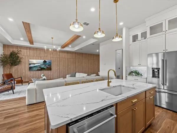 a kitchen with a sink a counter space appliances and cabinets