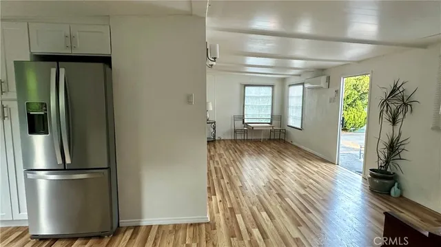 a kitchen with stainless steel appliances a refrigerator and wooden floor
