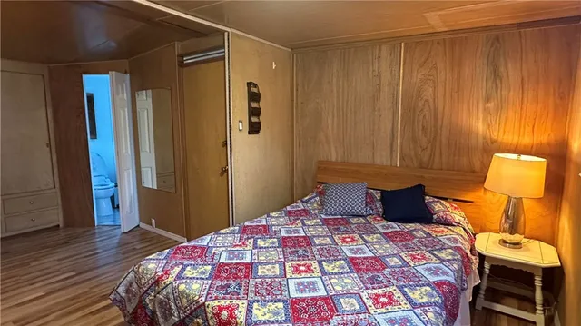 a bedroom with a bed and a lamp on dresser