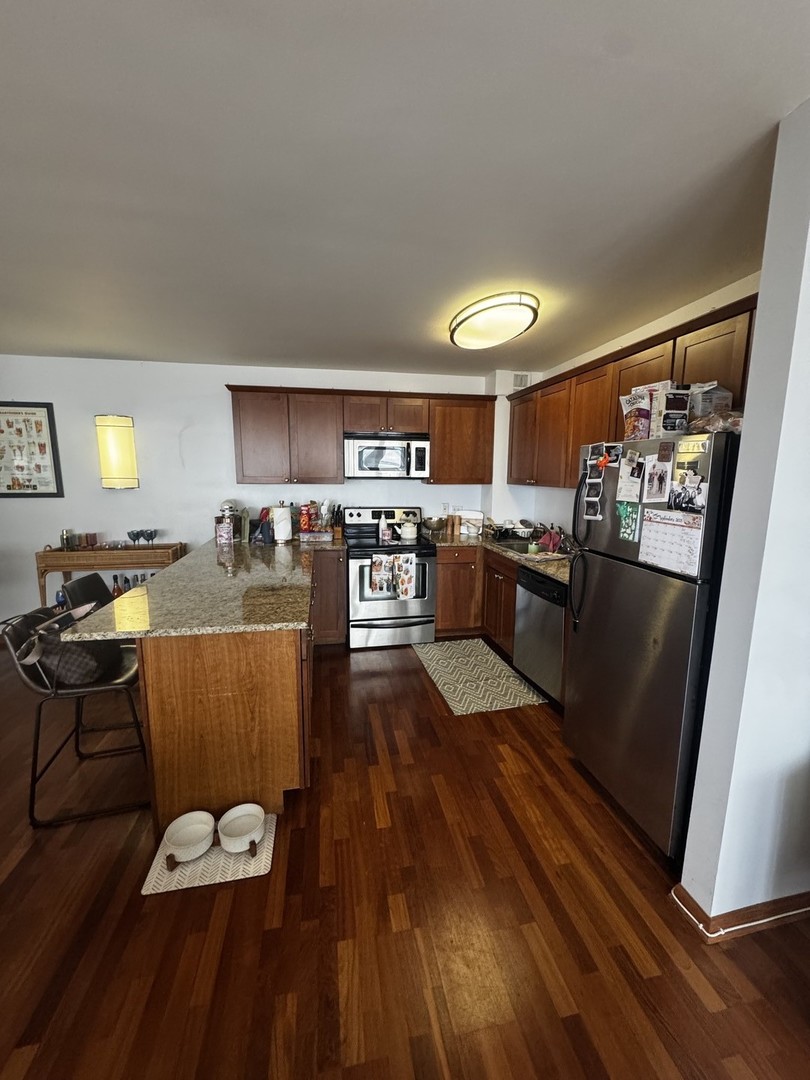 2933 North Sheridan Road, Unit 1201 Chicago, IL 60657 - Photo 4 of 16 a living room with stainless steel appliances granite countertop furniture wooden floor and a view of kitchen
