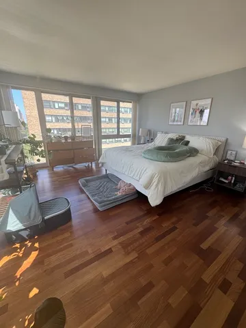 a spacious bedroom with a bed a couch and a large window