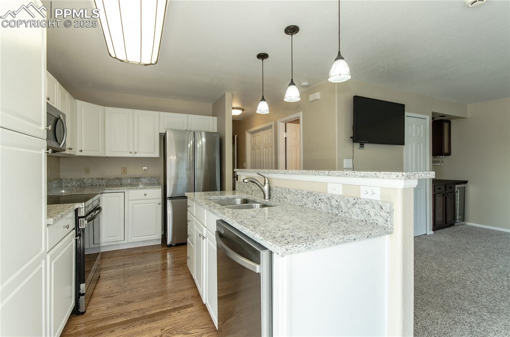 3216 Capstan Way Colorado Springs, CO 80906 - Photo 6 of 45 a kitchen with kitchen island granite countertop a sink a counter top space stainless steel appliances and cabinets