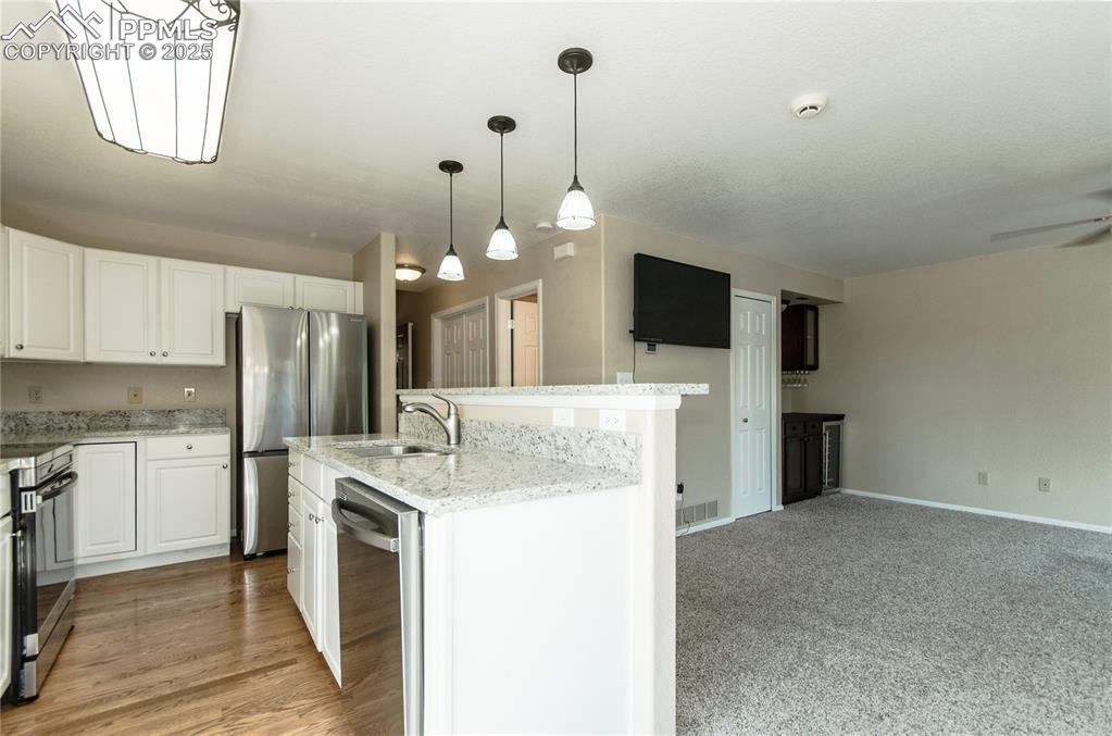3216 Capstan Way Colorado Springs, CO 80906 - Photo 7 of 45 a kitchen with a stove a refrigerator and a kitchen island