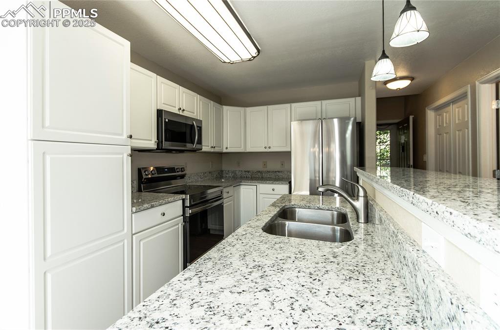 3216 Capstan Way Colorado Springs, CO 80906 - Photo 8 of 45 a kitchen with stainless steel appliances granite countertop a sink refrigerator stove and microwave