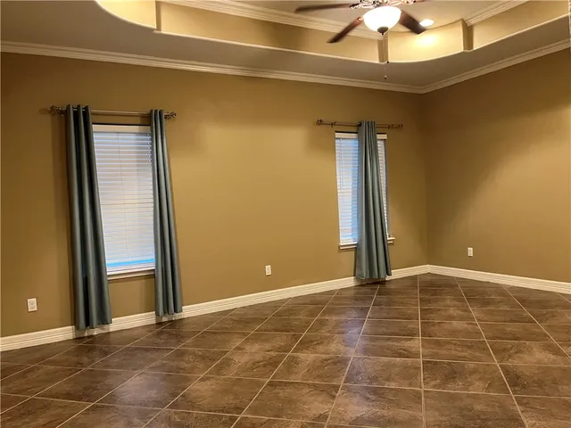 a view of an empty room with a cabinet and a window