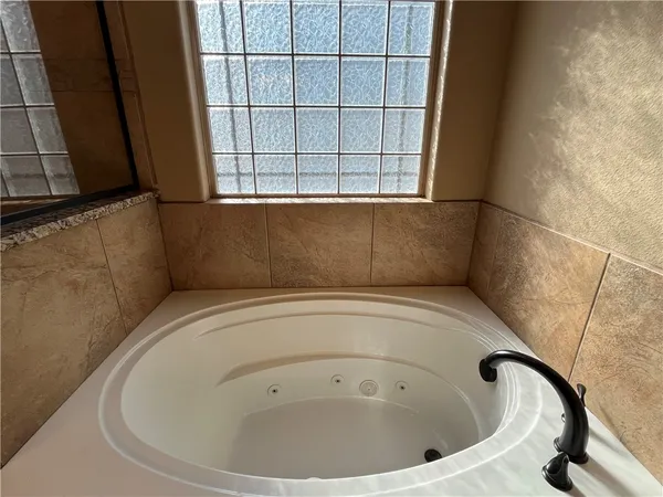 a bathroom with a granite countertop sink and a shower
