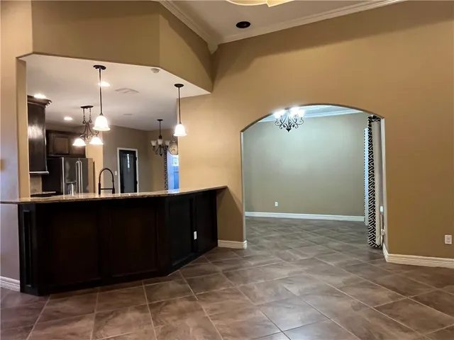 a view of kitchen with kitchen island wooden cabinets and refrigerator