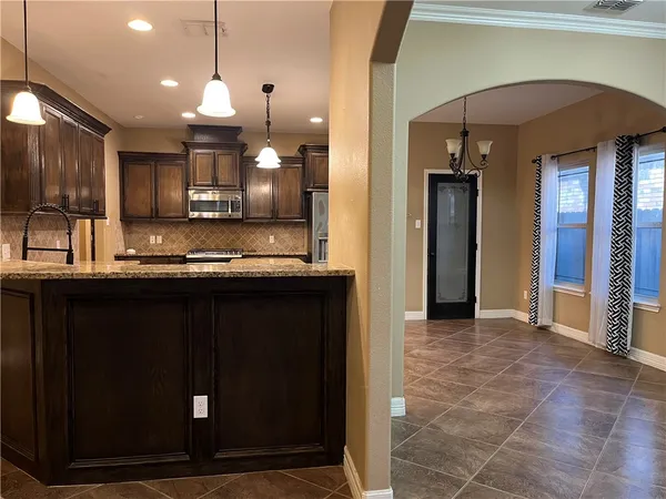 a view of a kitchen with a sink and refrigerator