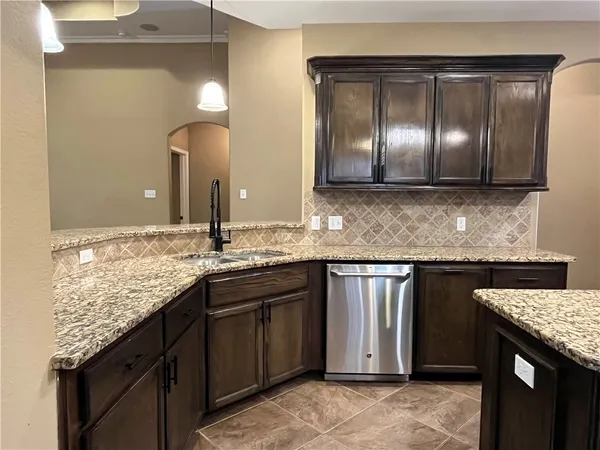 a kitchen with kitchen island granite countertop wooden cabinets and a refrigerator
