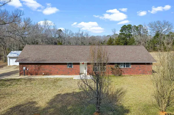 a view of house with pool and a yard