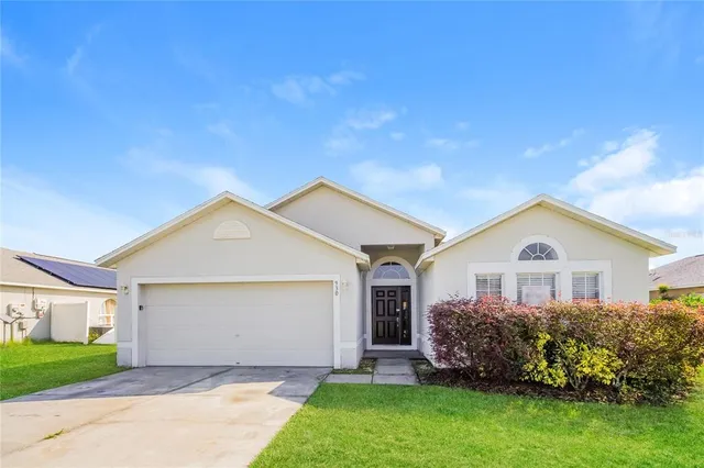 a front view of a house with a garden and plants