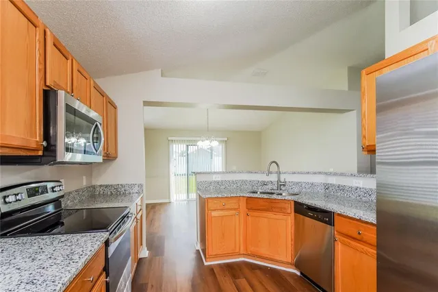 a kitchen with stainless steel appliances granite countertop a sink stove and microwave