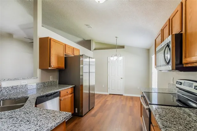 a kitchen with stainless steel appliances granite countertop a refrigerator and a stove top oven