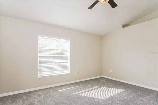 an empty room with a window and a fan