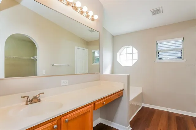 a room with a sink mirror and vanity