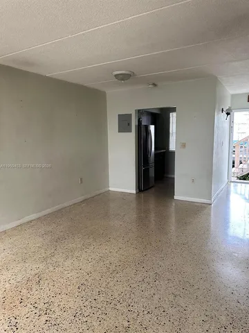 a view of a big room with wooden floor and windows