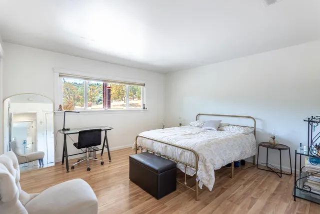 an empty room with wooden floor and window