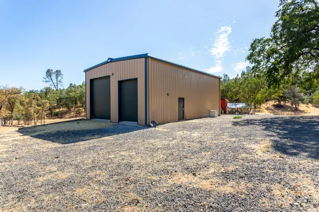 a view of a big house with a yard and large tree