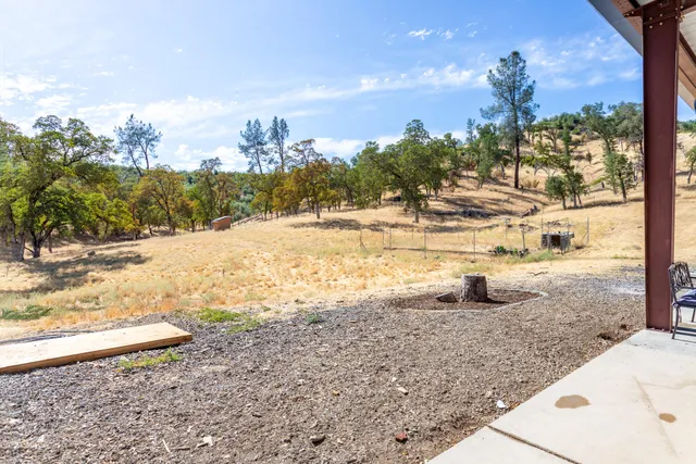 an aerial view of residential house with outdoor space and trees all around