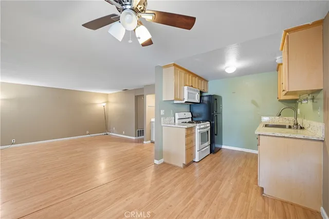 a kitchen with a sink cabinets stainless steel appliances and a window